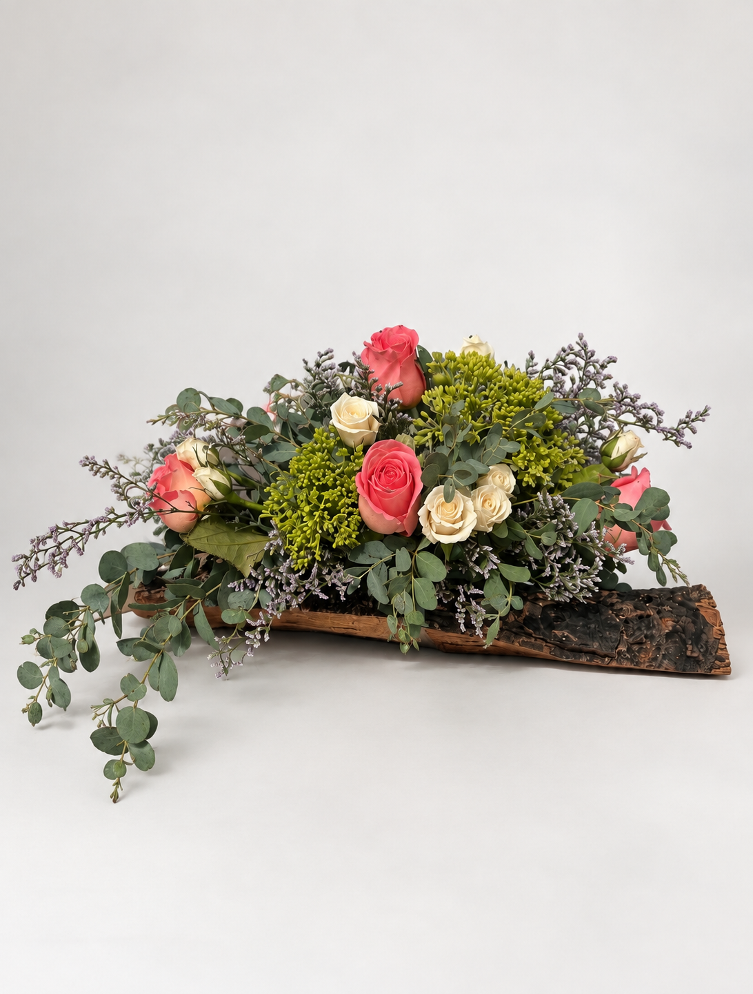 Diseño orgánico con rosas, eucalipto y delicados acentos en tonos morados.