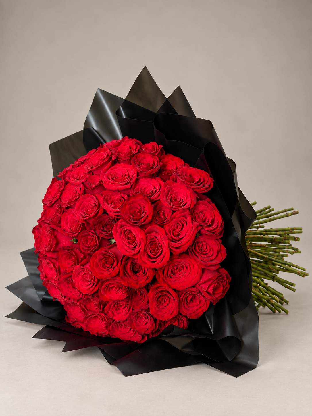 Ramo abundante de rosas rojas con envoltura negra, elegante y lleno de carácter.