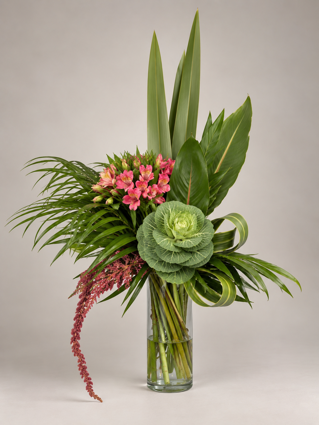 Diseño tropical de gran altura con follajes verdes y delicadas flores rosadas.